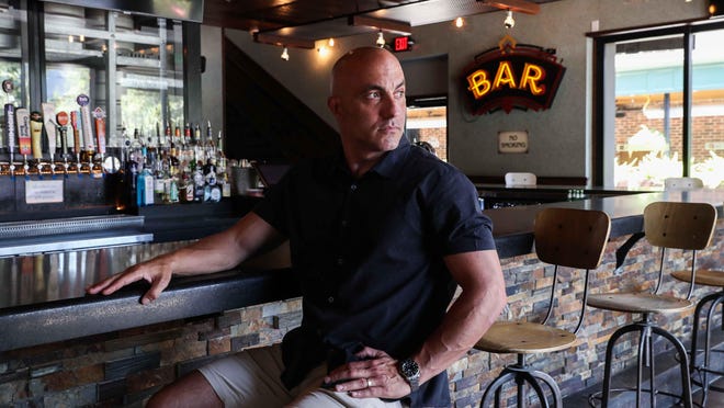 Jason Carrier, the Dogwood's owner poses at the empty bar on a business day. Carrier tries to find wiggle room under the governor's executive orders to reopen during the pandemic by serving more food.