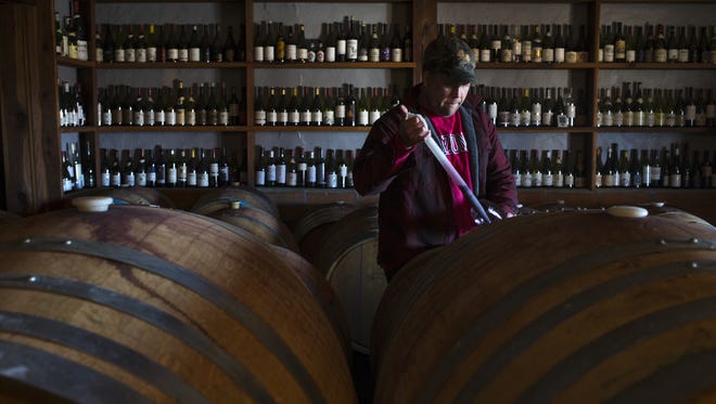 Todd Bostock draws wine from a barrel for tasting at Dos Cabezas WineWorks in Sonoita.