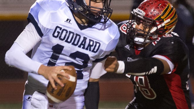 Centennial's Jerry Gurrola gets his hands on Goddard quarterback Cameron Stevenson causing him to throw the ball away & receive an intentional grounding penalty during third quarter action Friday night at the FIeld of Dreams.