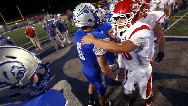 Fishers Tigers quarterback Zach Eaton shakes hands with Hamilton Southeastern's grant Skelton after the Tigers' 41-10 win over the Royals at HSE on Friday, September 12, 2014.
