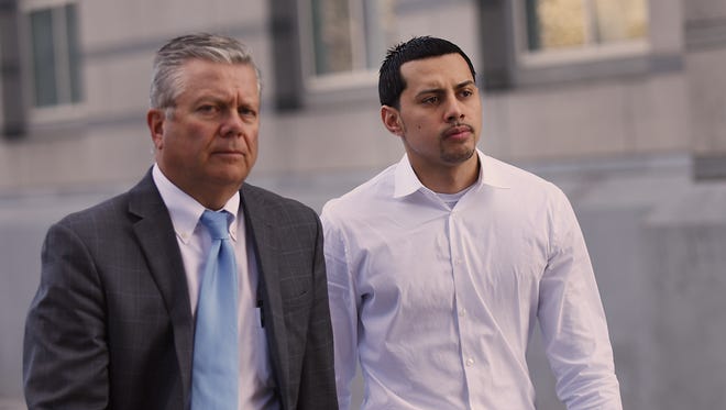 Paterson City police officer Ruben McAusland (right) appears at court in Newark after he is arrested on drug dealing charges on Friday April 20, 2018.