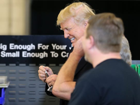 U.S. President Donald Trump smiles after signing an
