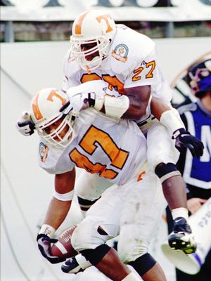 Tennessee linebacker Al Wilson (27) leaps on the back of teammate Tyrone Hines (47) after Hines intercepted a Northwestern pass and returned it for a touchdown during the third quarter of the Citrus Bowl Wednesday, Jan. 1, 1997 in Orlando, Fla. Tennessee won 48-28. They won the first BCS championship two years later.