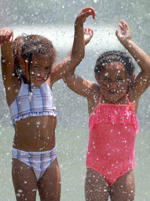Sisters Haidyn Burnely (5) and Miracle (3) have fun in the water coming from a fire hose at Shakedown Social Club's fifth annual Family Day, held Saturday, June 11, 2016, at Gallatin's Clearview Park.