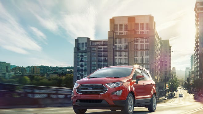 A red Ford EcoSport driving in a city.