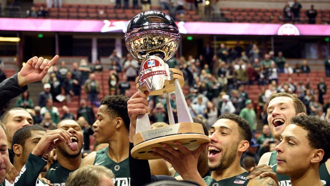 Michigan State Spartans guard Denzel Valentine holds the trophy for winning the Wooden Legacy Tournament against the Providence Friars as he celebrates with his team at Honda Center. The Michigan State Spartans won, 77-64.