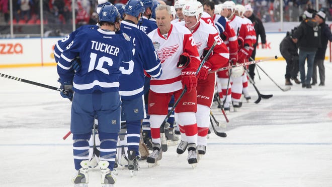 Former Red Wing and longtime Fox Sports Detroit hockey commentator Mickey Redmond leads the handshake line after the game.