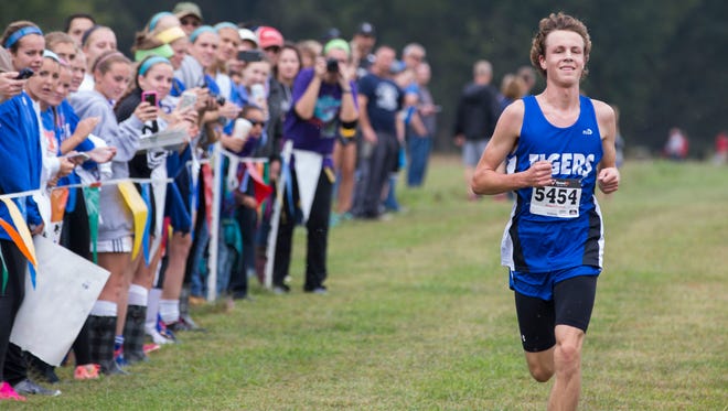 Matt Schadler of Memorial lets a smile cross his face as he approaches the finish line in first place during the SIAC cross country race on Saturday morning.