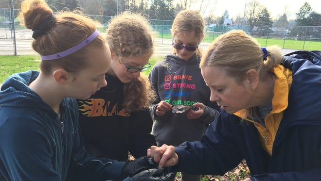 Maureen Foelkl works with a  group of students on a stream monitoring project at Orchard Heights Park on Nov. 19.