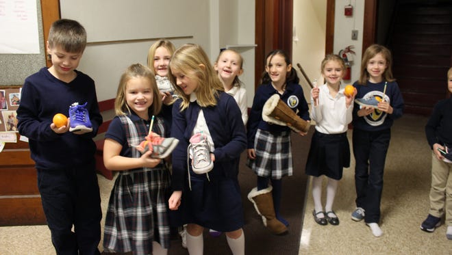 Miss Cross's first graders retrieve treats that St. Nicholas left in their shoes that had been placed in the hallway.