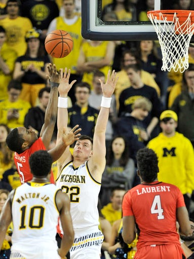 Michigan forward Ricky Doyle (32) defends a shot by