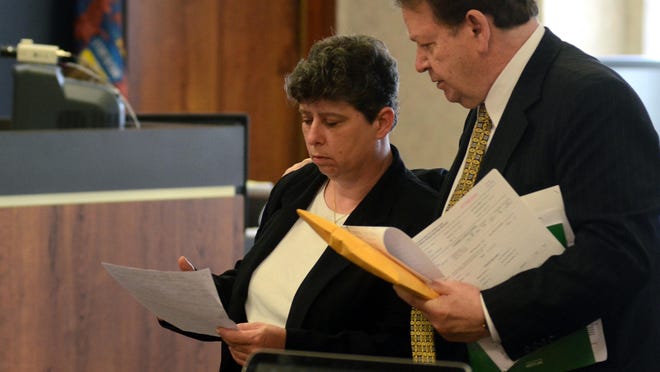 Former Clay Township clerk, Lisa White, is led out of the courtroom by her attorney, Arthur Garton on May 18.
