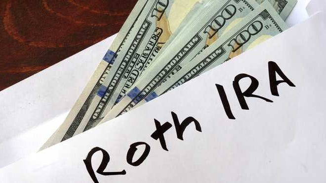 Envelope labeled ROTH IRA filled with cash.