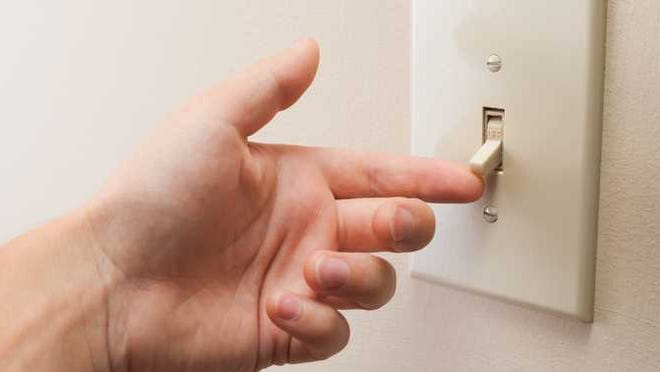 Finger flipping a light switch.