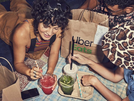 A group of friends enjoy food delivered by Uber Eats.