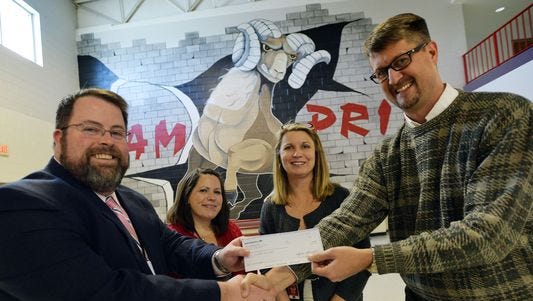 Claude Bray, human resources director of Bosch Rexroth Corporation, right, presents a $7,250 check to Bryan Skipper, principal of Hillcrest High School, left, as teachers Jennifer Southers and Kristin Hallman look on Feb. 10.