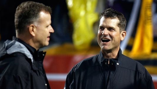 Michigan football coach Jim Harbaugh, right, with Jim Minick, associate athletic director for football, at the Baltimore Ravens' playoff game Jan. 3, 2015.