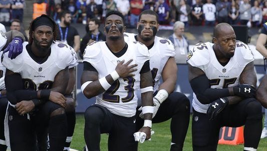 Baltimore Ravens players kneel down during the playing of the U.S. national anthem before an NFL football game against the Jacksonville Jaguars at Wembley Stadium in London, Sunday Sept. 24, 2017.