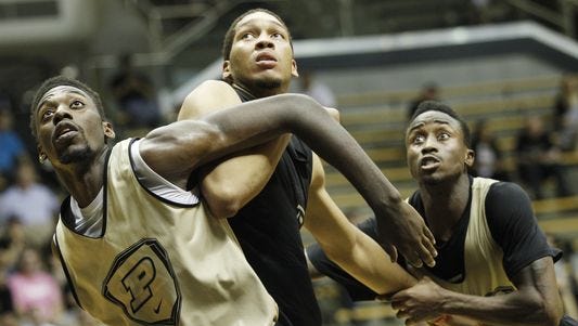 Jacquil Taylor, left, and Jon Octeus, right, work to keep A.J. Hammons out of rebounding position as Purdue men's basketball holds its second scrimmage Saturday, October 25, 2014, in Mackey Arena.