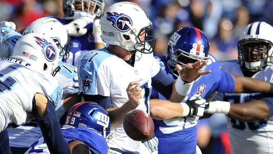 Titans quarterback Zach Mettenberger fumbles after a hit by Giants outside linebacker Devon Kennard during the first quarter Sunday in Nashville. Mettenberger reinjured his shoulder in the game and will miss the rest of the season.
(Photo: George Walker IV / The Tennessean)
