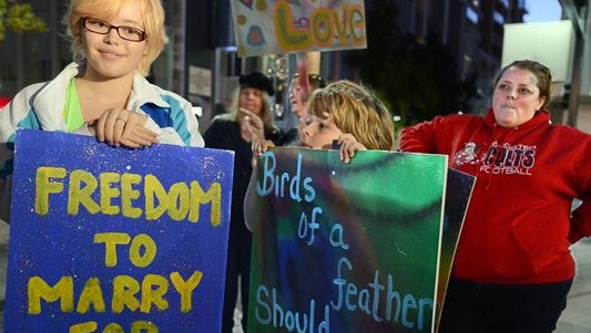 Sam Aaquist, 14, her brother, Billy, 10 and their mom, Joy, right, during the Celebration Rally for Marriage Equality at the Downtown Plaza Tuesday evening Oct. 7, 2014.