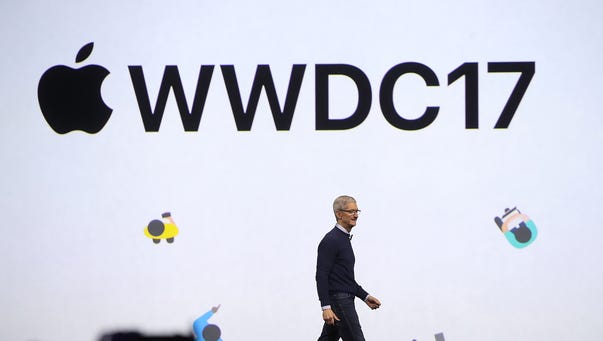 Apple CEO Tim Cook walks on stage to deliver the opening