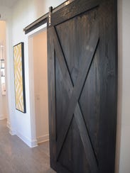 A wooden barn door is used to separate the den from