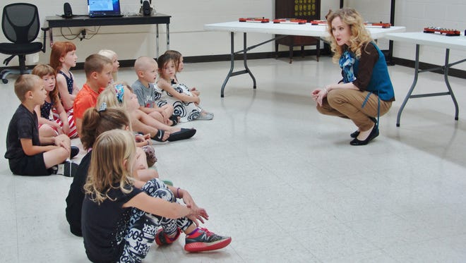 Samantha Servais talks to kids about music during the first session of Sing It, Play It, Dance It.
