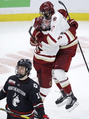 JD Dudek (center) is congratulated by teammate and former Boston College men's hockey player David Cotton after his goal against Northeastern during the third period of the NCAA hockey Beanpot tournament championship game in Boston on Feb. 11, 2019. Cotton is one of many college hockey players who has missed out on playing in the NHL or AHL this spring. [AP File Photo/Charles Krupa)
