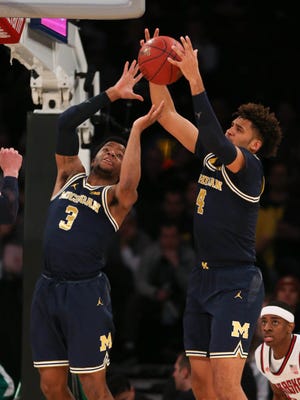 Michigan guard Zavier Simpson and forward Isaiah Livers rebound during first half action against Nebraska Friday, March 2, 2018 at Madison Square Garden in New York.