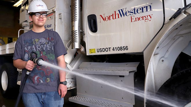 Andy Tveter, 18, washes mud off the truck floors at NorthWestern Energy's Great Falls division office in Black Eagle. Tveter, the handyman, was hired by the energy company through Great Falls Public School's Secondary Life Skills Program. The program provides special needs students with skills to be successful upon graduation.