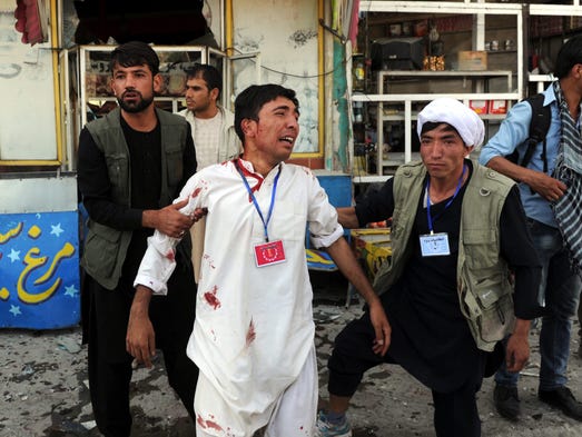 People help an injured victim after a suicide bomb