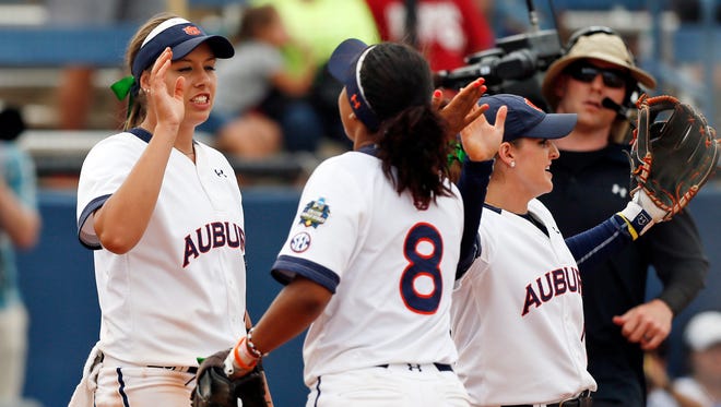 Auburn's Kaylee Carlson, left, Jade Rhodes (8) and Kasey Cooper celebrate after a softball game against UCLA in the NCAA Women's College World Series in Oklahoma City, Thursday, June 2, 2016. Auburn won 10-3.