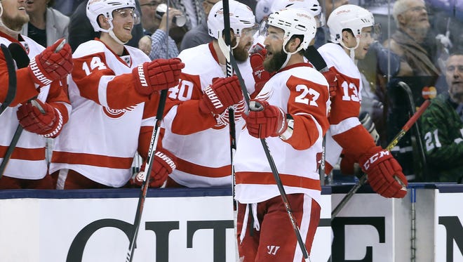 Red Wings defenseman Kyle Quincey (27) is congratulated by teammates on the bench after scoring a goal in the third period of the Wings' 3-2 win over the Leafs Saturday in Toronto.