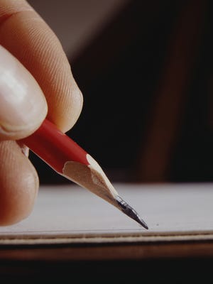 Man writing with pencil, close-up of hand