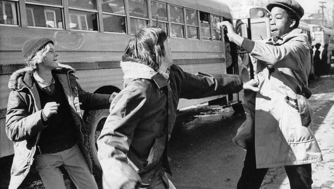 White and black students begin to fight outside Hyde Park High School in Boston, Mass., Feb. 14, 1975. The city of Boston started a court-ordered school integration program requiring the busing of 18 percent of public school students. (AP Photo/DPG)