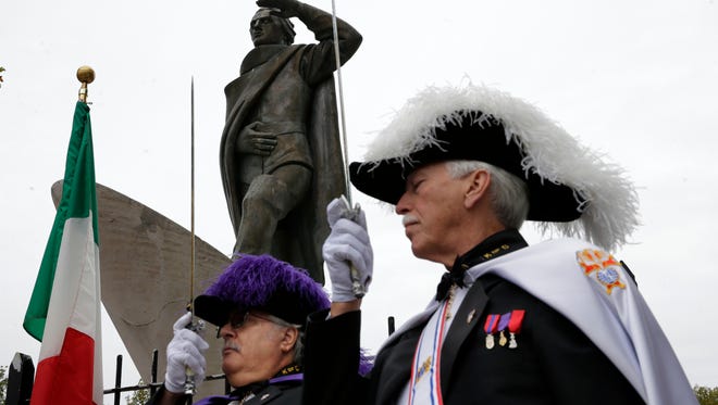 Members the Knights of Columbus salute near a statue of Christopher Columbus during a Columbus Day Commemoration in Trenton, N.J., in 2014.