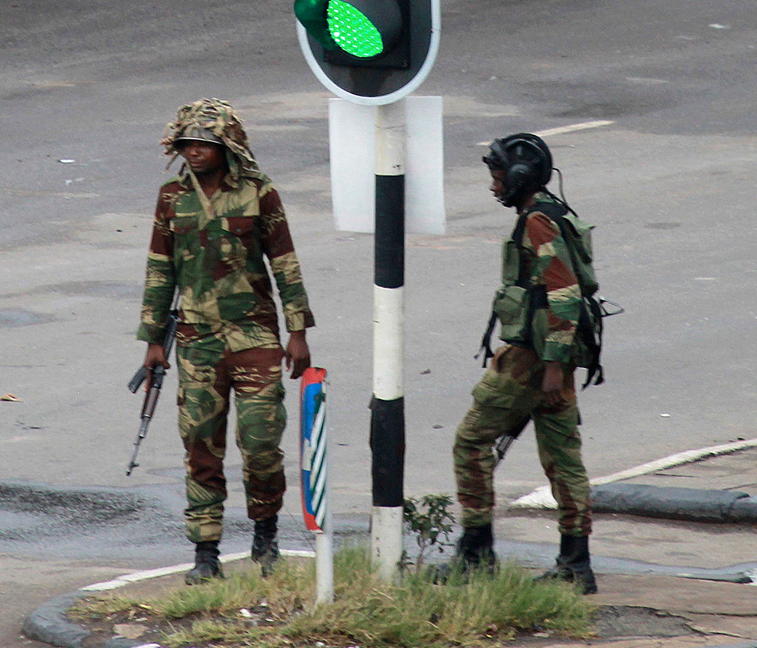Armed soldiers stand on the road leading to President Robert Mugabe's office in Harare, Zimbabwe Wednesday, Nov. 15, 2017.