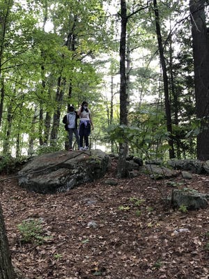 Nidhi Kalimreddy and Isabel Bernardo, sixth graders at the Blanchard School, leave kindess rocks at the Acton Arboretum.