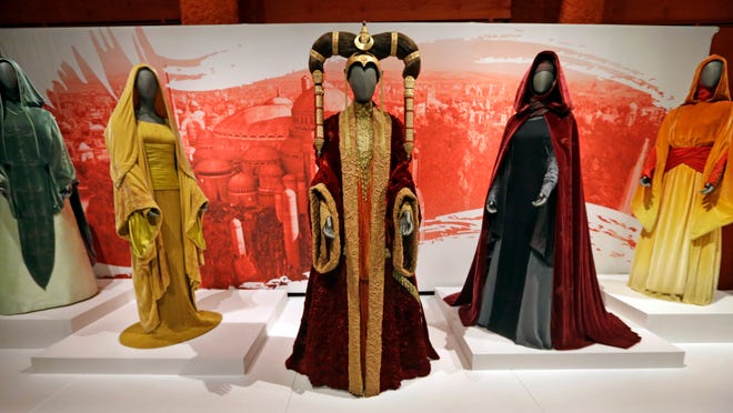 In this photo taken Thursday, Jan. 29, 2015, the Senate gown of Queen Amidala, center, is seen with handmaiden gowns on display as part of an exhibit on the costumes of Star Wars at Seattle’s EMP Museum.