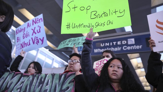People with Asian community organizations from Chicago hold signs to protest during rally near United Airlines’ counter at the airport's Terminal 1 in Chicago on Tuesday.