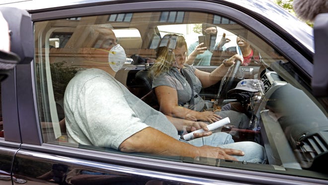 Ohio House Speaker Larry Householder, in the front passenger seat of the vehicle, is held up by protesters blocking his vehicle while leaving at the Federal Courthouse in Columbus on Tuesday July 21, 2020.