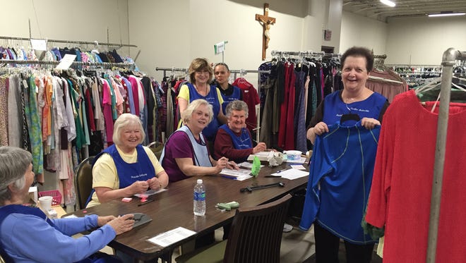 Volunteers get ready for the Ladies of Charity sale, which opens Friday at the Ladies of Charity shop.