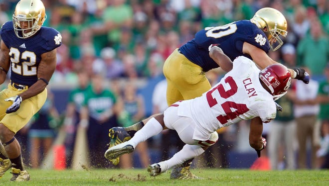 Notre Dame  linebacker Ben Councell (30) breaks up a pass intended for Oklahoma  running back Brennan Clay (24) in the fourth quarter at Notre Dame Stadium. Councell was called for a targeting penalty on the play and ejected.