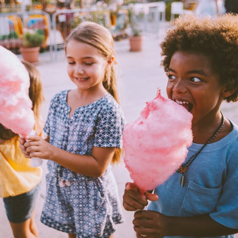 Kids eating cotton candy at a theme park.