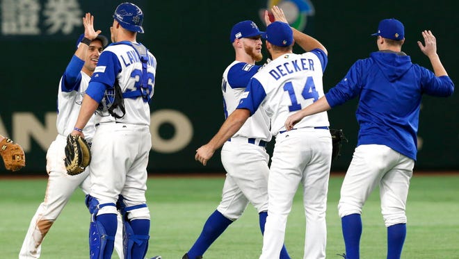 March 12: Israel's catcher Ryan Lavarnway and Cody Decker celebrate with teammates after beating Cuba 4-1.