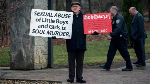 Robert Hoatson, an ex-priest, is a lone protestor outside a press conference where Attorney General Kathleen Kane announced criminal conspiracy charges against leaders of the Franciscan Order located in Holidaysburg, Pa., on Tuesday, March 15, 2016, in Johnstown, Pa. Three ex-leaders of the Franciscan religious order were charged Tuesday with allowing a friar who was a known sexual predator to take on jobs, including a position as a high school athletic trainer, that enabled him to molest more than 100 children.