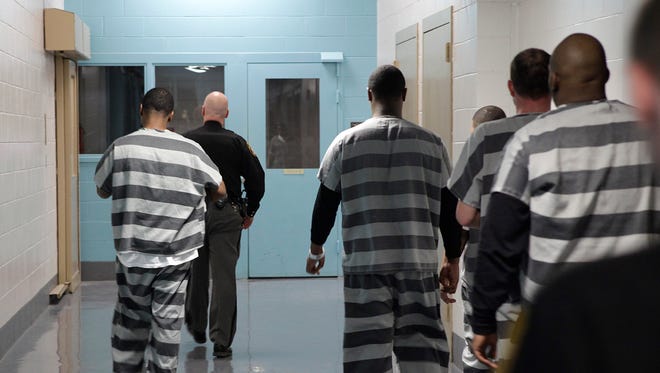 Prisoners walk down the hallway at the Hamilton County Justice Center during the intake process