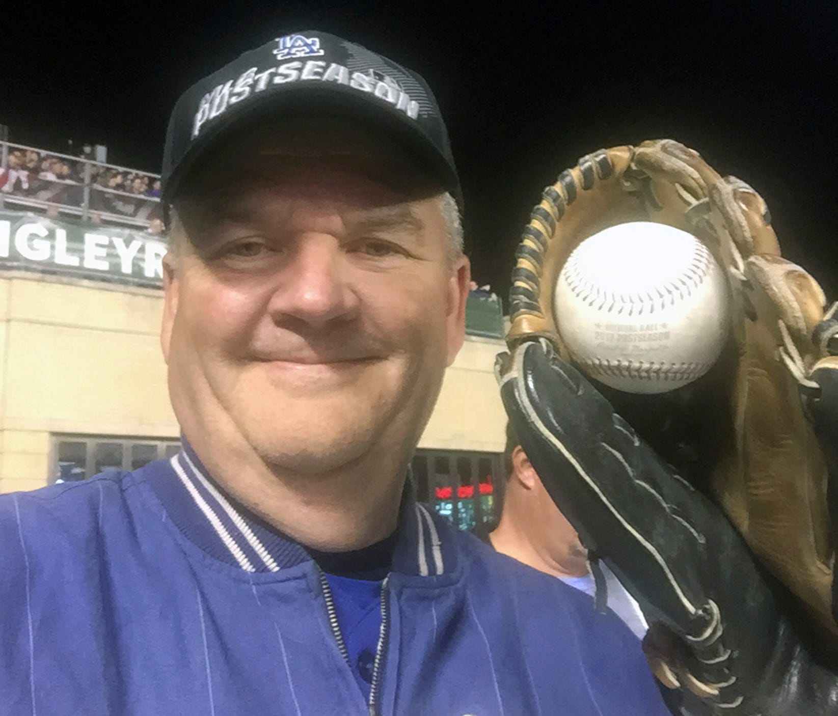 Los Angeles Dodgers fan Keith Hupp holds a home run ball hit by the Chicago Cubs' Javier Baez in the fifth inning of Game 4 of the NLCS.