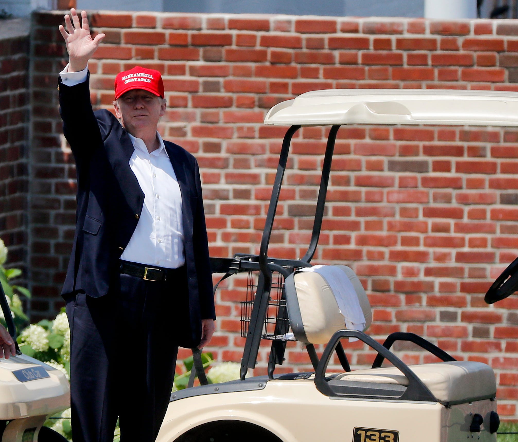 President Trump waves to spectators as he walks out of his residence at the Trump National Golf Club during the third round of the U.S. Women's Open Golf tournament, July 15, 2017, in Bedminster, N.J. (